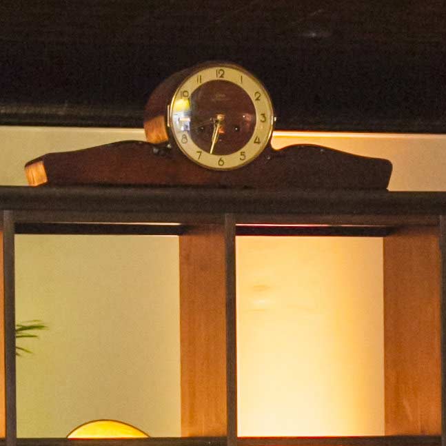 Antike Uhr auf dunklem Holzregal